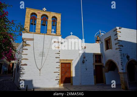 Église Agios Ioannis Prodromos, Une église avec un clocher en pierre de couleur claire et des murs blancs sur une île grecque sous un ciel bleu, Skala, Patmos Banque D'Images