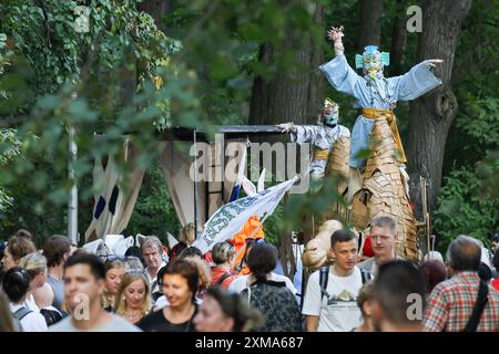 Pétersbourg, Russie. 26 juillet 2024. La procession cérémonielle du festival de théâtre de rue sur l'île d'Elagin à Pétersbourg. Le festival a ouvert le soir du 26 juillet avec une procession théâtrale de la station de métro Krestovsky Ostrov à Maslyany Lug sur l'île d'Elagin. Des artistes dans divers costumes colorés ont interprété divers numéros interactifs pour le public, tels que des danses, des numéros de jeu, des improvisations et de grandes danses rondes. Crédit : SOPA images Limited/Alamy Live News Banque D'Images