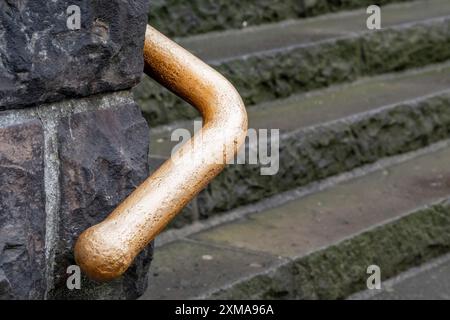 Gros plan d'une main courante en métal usée d'un escalier, au point Banque D'Images