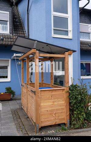 Maison individuelle avec divers modules solaires, en plus des panneaux solaires sur le toit de la maison, des modules solaires enfichables sont montés sur une boîte à poubelle Banque D'Images