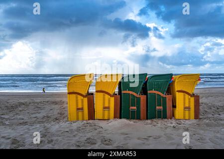 Fin de saison sur la plage, nuages sombres, mer agitée, automne sur la mer du Nord en Hollande du Nord, près d'Egmond aan Zee, chaises de plage prêtes pour Banque D'Images