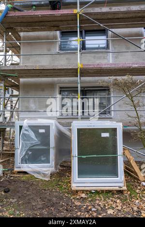 Rénovation énergétique d'un immeuble résidentiel, nouvelles fenêtres en attente d'installation, sur un chantier Banque D'Images