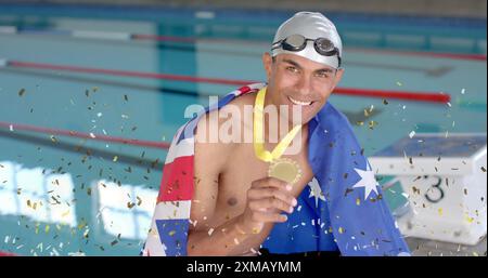 Image de confettis au-dessus d'un nageur masculin biracial tenant la médaille avec le drapeau de l'australie Banque D'Images