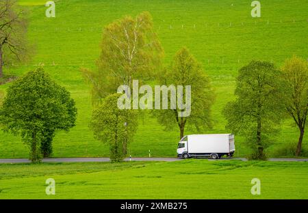 Camion sur une route de campagne, champs verts, prairies, arbres bordent la route à 2 voies, printemps, près de Schwelm, Rhénanie du Nord-Westphalie, Allemagne Banque D'Images