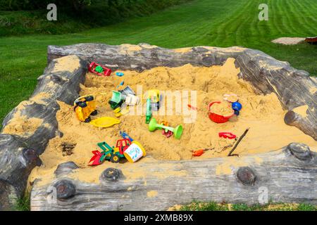 Bac à sable, sur une aire de jeux pour enfants, bac à sable avec divers jouets en plastique, excavatrice, pelles, moules Sauerland, Rhénanie-du-Nord-Westphalie, Allemagne Banque D'Images