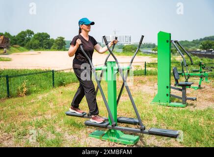 Jeune femme russe faisant des exercices sur un entraîneur elliptique extérieur Banque D'Images