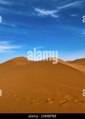 Empreintes de pas dans le sable des dunes désertiques erg chebbi contre ciel bleu, Maroc Banque D'Images