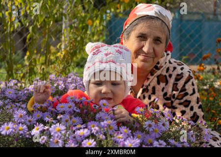 portrait d'automne de grand-mère avec petite-fille en fleurs Banque D'Images