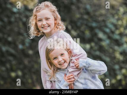 En plein air, rire et frères et sœurs en portrait avec câlin, ludique et de liaison avec des jeux d'enfance dans le parc. Jardin, enfants ou filles avec étreinte Banque D'Images