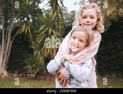 Jardin, heureux et frères et sœurs en portrait avec câlin, ludique et de liaison avec des jeux d'enfance dans le parc. En plein air, enfants ou filles avec étreinte Banque D'Images