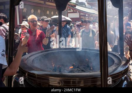 Tokyo, Japon - 15 juin 2024 : de nombreux touristes visitent le temple Senso-Ji, le plus ancien temple de Tokyo, pendant une journée d'été. La fumée sacrée de sens Banque D'Images