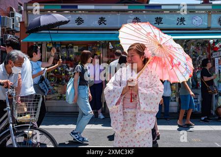 Tokyo, Japon - 15 juin 2024 : une femme porte un kimono en visitant Nakamise, la rue commerçante la plus célèbre d'Asakusa près du temple Senso-Ji, Toky Banque D'Images