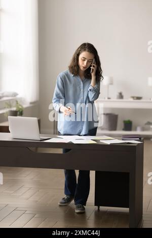 Femme parlant sur smartphone discutant de questions professionnelles importantes à un collègue Banque D'Images