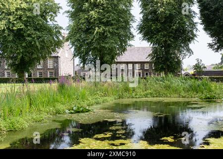 Gracehill, Irlande du Nord - 26 juillet 2024 : une colonie morave historique obtient le statut de patrimoine mondial de l'UNESCO. Bâtiments du village vus de l'autre côté de l'étang. Banque D'Images