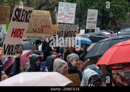 Melbourne, Australie. 27 juillet 2024. Les manifestants tiennent des pancartes exprimant leur opinion pendant la manifestation. Malgré la pluie, les gens se sont rassemblés pour protester contre les violences faites aux femmes, après que 54 femmes ont été tuées cette année en raison de violences domestiques, les auteurs de ces violences étant principalement des hommes. Les manifestants appellent le gouvernement australien à agir. Crédit : SOPA images Limited/Alamy Live News Banque D'Images