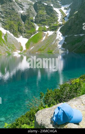 Vacances actives à la montagne. Chapeau sur une pierre. Black Lake en contrebas du mont Rysy. Montagnes des Tatra, Pologne. Banque D'Images