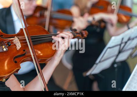Orchestre symphonique professionnel se produisant sur scène et jouant un concert de musique classique, violoniste jouant au premier plan, art et divertissement co Banque D'Images