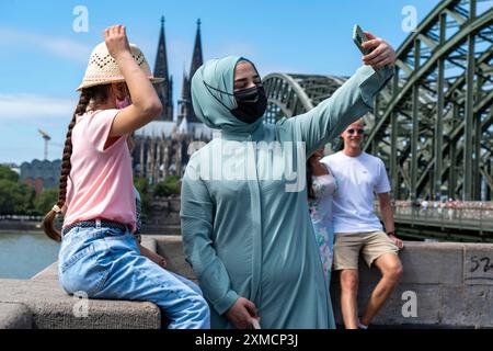 Les touristes prennent une photo souvenir en face de la cathédrale de Cologne, sur le Deutzer Ufer, le pont Hohenzollern, pont ferroviaire sur le Rhin, Cologne, Nord Banque D'Images