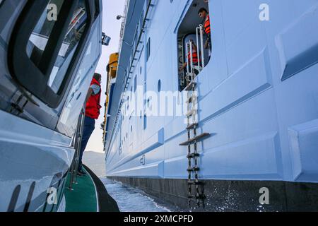 Nice, France : bateau pilote portuaire approchant l'HYMNE DES MERS géant de Royal Caribbean pour embarquer le pilote maritime à Villefranche sur mer. Une escale unique pour le plus grand bateau de croisière cette année dans le petit port de la Côte d'Azur. Après la saison estivale, l'impressionnant navire devait naviguer à travers le canal de Suez dans le cadre d'un repositionnement de l'Europe vers un nouveau port d'attache à Singapour, mais à la suite des tensions de la mer Rouge et des menaces d'attaques de missiles Houthi sur les navires, il transportera plutôt sans passager autour de la pointe sud de l'Afrique pour rejoindre Dubaï et l'Asie. Crédit : Kevin Izorce/Alamy Live News Banque D'Images