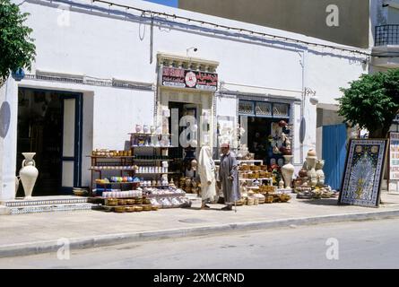 La céramique, Nabeul, Tunisie. Magasin de poterie. L'homme et la femme en costume traditionnel de parler. Banque D'Images