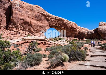 Moab, Utah, États-Unis - 22 avril 2017 : visiteurs sur un sentier vers l'Arche North Window dans la section Windows du parc national Arches Banque D'Images