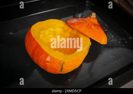 Citrouille entière cuite au four avec le dessus coupé. Citrouille prête à être versée dans la soupe. Recette de soupe écrasée. Photo de haute qualité Banque D'Images