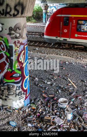 Bidons de peinture en aérosol vides, sur une ligne de chemin de fer sous un pont routier, jetés, jetés par le pulvérisateur, graffiti, tas de déchets, Essen, Nord Banque D'Images