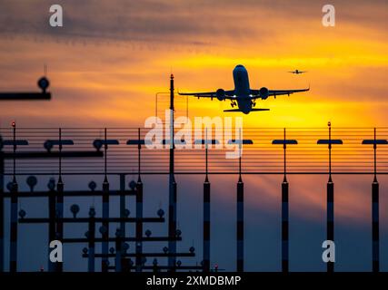 Éclairage de piste, aides à l'approche, à l'aéroport international de Duesseldorf, coucher de soleil, avions décollant et approchant de la piste principale sud, 05R/23L. Banque D'Images