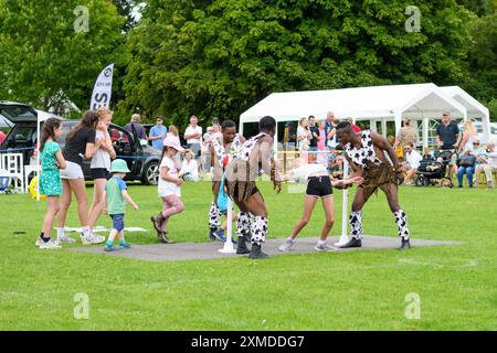 Damerham, Fordingbridge, Hampshire, Angleterre, Royaume-Uni, 27 juillet 2024. L'équipe acrobatique des Black Eagles invite les enfants à essayer une danse limbo à la foire et au spectacle horticole de Damerham Village. Crédit : Paul Biggins/Alamy Live News Banque D'Images