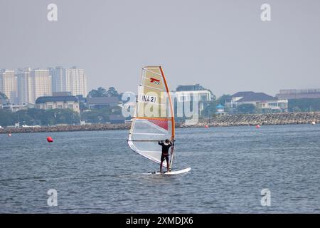 Jakarta, Indonésie, 27 juillet 2024 Muhammad Haikal en compétition pour Techno 293 GARÇONS lors du Championnat international de voile de Jakarta 2024 avec North Jakarta Skyline à Symphony of the Sea, Ancol, Jakarta, Indonésie, Credit Shaquille Fabri/ Alamy Live News Banque D'Images