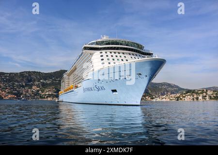 Nice, France : HYMNE DES MERS DE Royal Caribbean à Villefranche sur mer pour une escale unique pour le plus grand bateau de croisière cette année dans le petit port de la Côte d'Azur. L'immense navire accueille autant de passagers que les habitants du village. Après la saison estivale, l'impressionnant navire devait naviguer à travers le canal de Suez dans le cadre d'un repositionnement de l'Europe vers un nouveau port d'attache à Singapour, mais à la suite des tensions de la mer Rouge et des menaces d'attaques de missiles Houthi sur les navires, il transitera plutôt sans passager autour de la pointe sud de l’Afrique pour rejoindre Dubaï puis l’Asie. Crédit : Kevin Izorce/Alamy Live News Banque D'Images