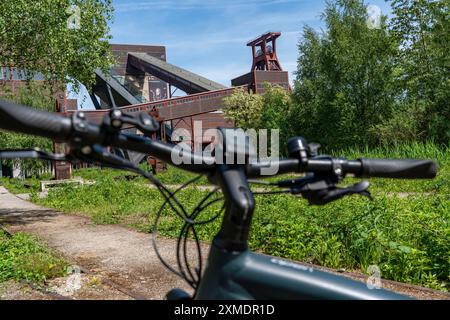 Vélo dans la région de la Ruhr, en vélo, e-bike, au complexe industriel de la mine de charbon de Zollverein site du patrimoine mondial, arbre de tour d'enroulement à double chevalet Banque D'Images