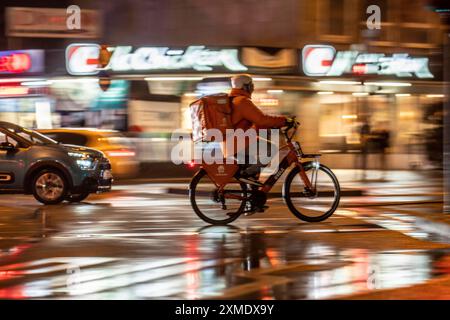 Rue à la gare principale, Lieferando coursier, cycliste, temps pluvieux, centre-ville, dans la soirée, Essen, Rhénanie du Nord-Westphalie, Allemagne Banque D'Images