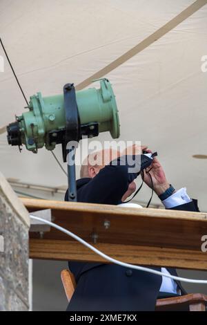 officiel de l'escadron royal de yacht regardant à travers des jumelles lors de la régate annuelle cowes week sur l'île de wight Banque D'Images