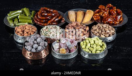 Divers écrous dans des bols en cuivre vue de dessus. Sélection de noix, noix de cajou, amandes, bonbons aux amandes, lukum turc, noisettes et pistaches se mélangent. fitness sain Banque D'Images