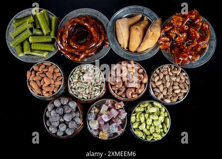 Divers écrous dans des bols en cuivre vue de dessus. Sélection de noix, noix de cajou, amandes, bonbons aux amandes, lukum turc, noisettes et pistaches se mélangent. fitness sain Banque D'Images