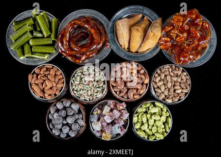 Divers écrous dans des bols en cuivre vue de dessus. Sélection de noix, noix de cajou, amandes, bonbons aux amandes, lukum turc, noisettes et pistaches se mélangent. fitness sain Banque D'Images