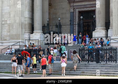 Touristes assis sur les marches de la basilique Saint-Étienne lors d'une chaude journée d'été à Budapest Banque D'Images