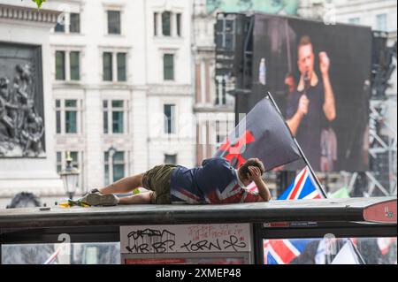 Un partisan de Tommy Robinson vu au sommet d'un arrêt de bus alors qu'il assistait au rassemblement à Trafalgar Square. Les partisans de l’ex-dirigeant de l’EDL (Ligue de défense anglaise) et fondateur Tommy Robinson, de son vrai nom Stephen Christopher Yaxley-Lennon, ont défilé vers Trafalgar Square pour manifester contre ce qu’ils appellent un « système de police à deux vitesses », l’immigration et le mouvement LGBTQ+. Une contre-manifestation a également été organisée par divers groupes. (Photo de David Tramontan / SOPA images/SIPA USA) Banque D'Images