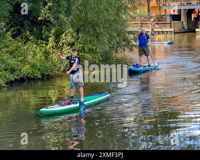 A281, Guildford. 27 juillet 2024. Un bel après-midi chaud et ensoleillé pour les Home Counties alors qu'une crête de haute pression s'est installée. Les paddleboarders apprécient le temps qu'il fait devant le Weyside Pub à Guildford dans le Surrey. Crédit : james jagger/Alamy Live News Banque D'Images