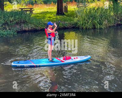 A281, Guildford. 27 juillet 2024. Un bel après-midi chaud et ensoleillé pour les Home Counties alors qu'une crête de haute pression s'est installée. Les paddleboarders apprécient le temps qu'il fait devant le Weyside Pub à Guildford dans le Surrey. Crédit : james jagger/Alamy Live News Banque D'Images