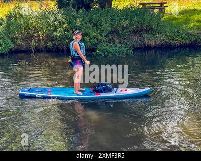 A281, Guildford. 27 juillet 2024. Un bel après-midi chaud et ensoleillé pour les Home Counties alors qu'une crête de haute pression s'est installée. Les paddleboarders apprécient le temps qu'il fait devant le Weyside Pub à Guildford dans le Surrey. Crédit : james jagger/Alamy Live News Banque D'Images