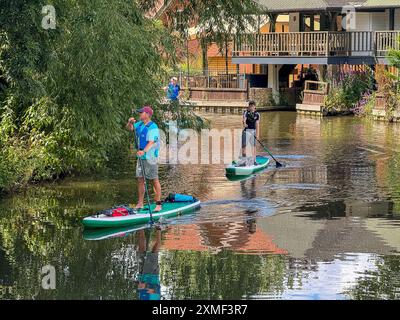 A281, Guildford. 27 juillet 2024. Un bel après-midi chaud et ensoleillé pour les Home Counties alors qu'une crête de haute pression s'est installée. Les paddleboarders apprécient le temps qu'il fait devant le Weyside Pub à Guildford dans le Surrey. Crédit : james jagger/Alamy Live News Banque D'Images