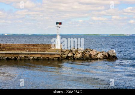 Phare sur une jetée de pierre dans la mer Baltique dans un paysage côtier en face du fort de Kungsholms dans le sud de la Suède en été. Banque D'Images