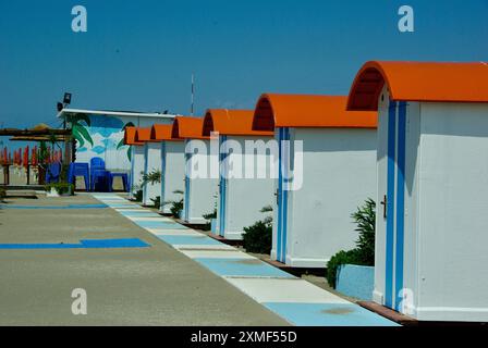 Cabines de baignade dans une rangée sur une plage de sable à la mer Adriatique en Italie en été. Banque D'Images