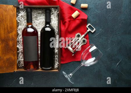 Composition avec des bouteilles de vin, verre et tire-bouchon sur fond sombre Banque D'Images