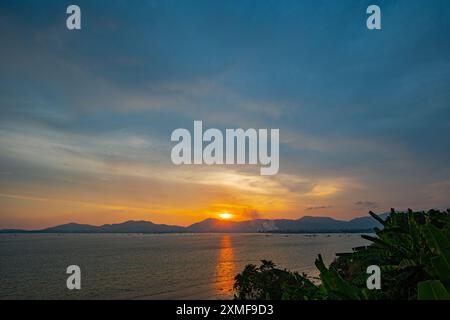 Les nuages moelleux obscurcissent le magnifique ciel alors que le soleil se couche sur la mer. fond de nuages doux et moelleux. incroyable les nuages doux ont déplacé les formes dedans Banque D'Images