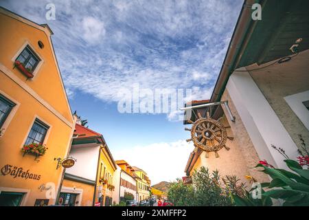 Autriche - 26 octobre 2023 : vue sur une rue étroite d'un village européen. La rue est bordée de bâtiments colorés et un ciel bleu avec c moelleux Banque D'Images