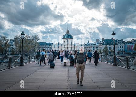 Paris, France - 19 octobre 2023 : Un homme traverse un pont à Paris, France. La Seine peut être vue en arrière-plan. Banque D'Images