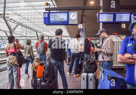 Les passagers attendent les trains dans une gare de Rotterdam, aux pays-Bas, le 26 juillet 2024. Le trafic TGV français sur les lignes Atlantique, Nord et est a été gravement perturbé en raison d'incendies criminels ciblant des installations, la compagnie ferroviaire nationale française SNCF. La compagnie ferroviaire française SNCF déclare que 800 000 clients ont été touchés et qu'elle envisage de mobiliser des centaines de personnes pour réparer le réseau le plus rapidement possible. Les personnes des pays-Bas qui se rendent à Paris pour l'ouverture des Jeux Olympiques vendredi font face à des trajets plus longs après sabotag de nuit Banque D'Images